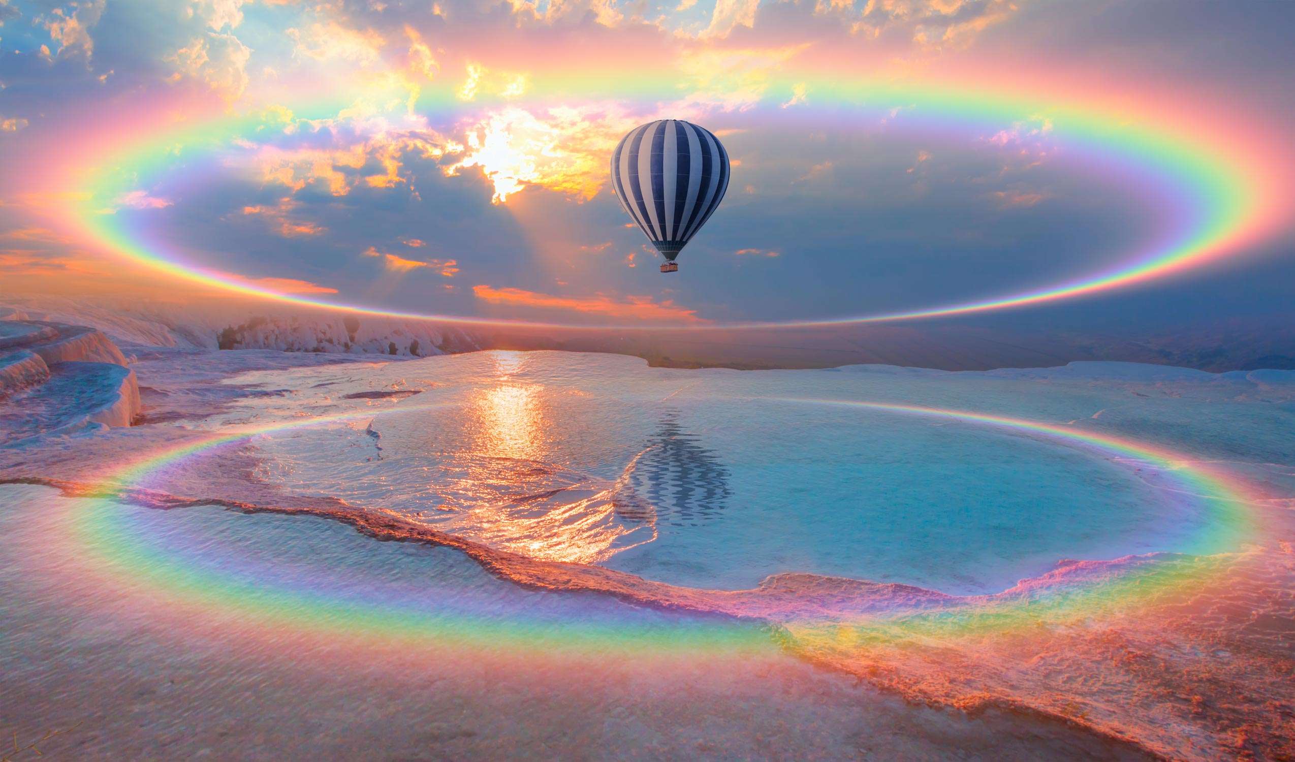 Hot air balloon flying over spectacular pamukkale with amazing rainbow 