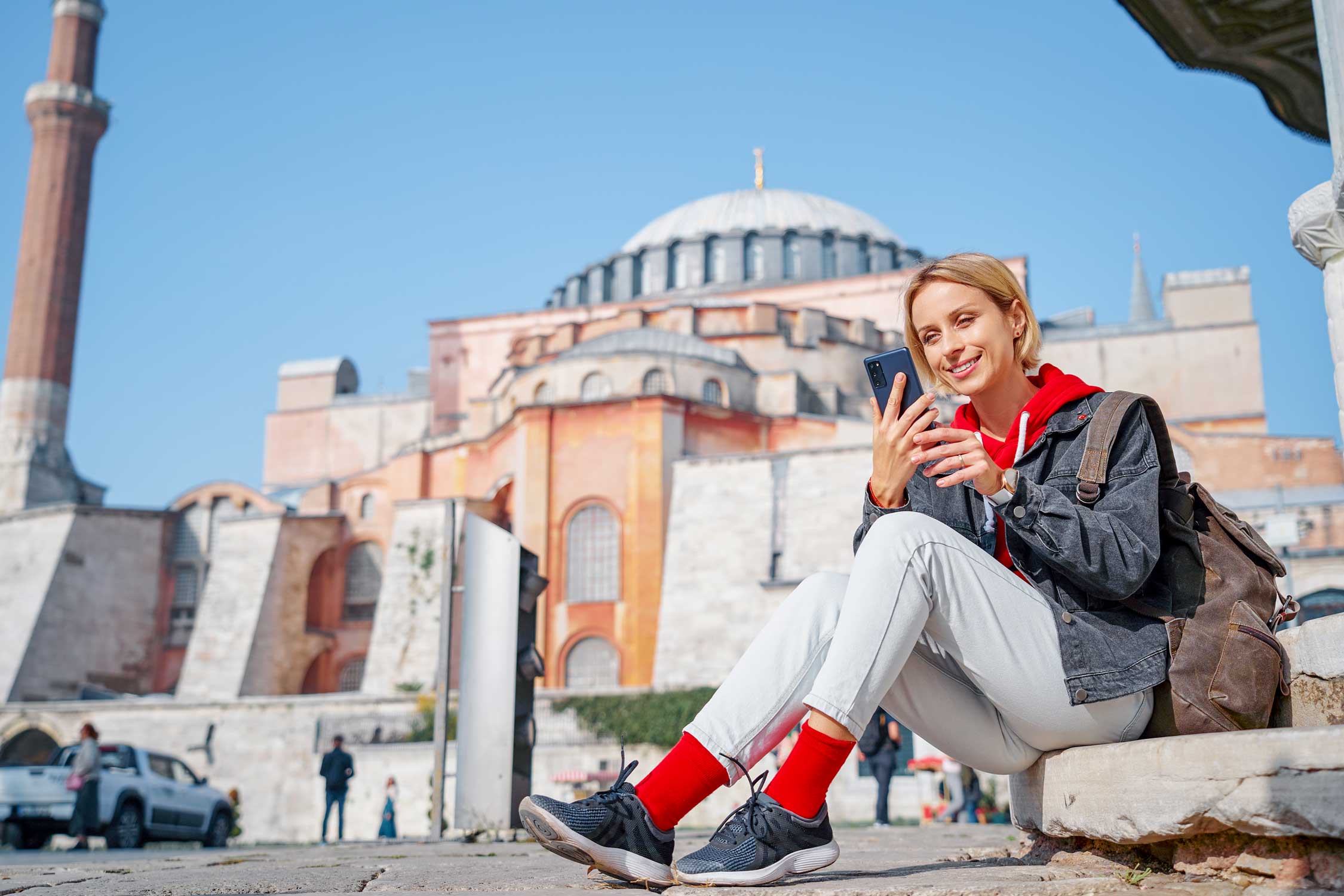 Young traveling woman using smartphone near Hagia Sophia Temple