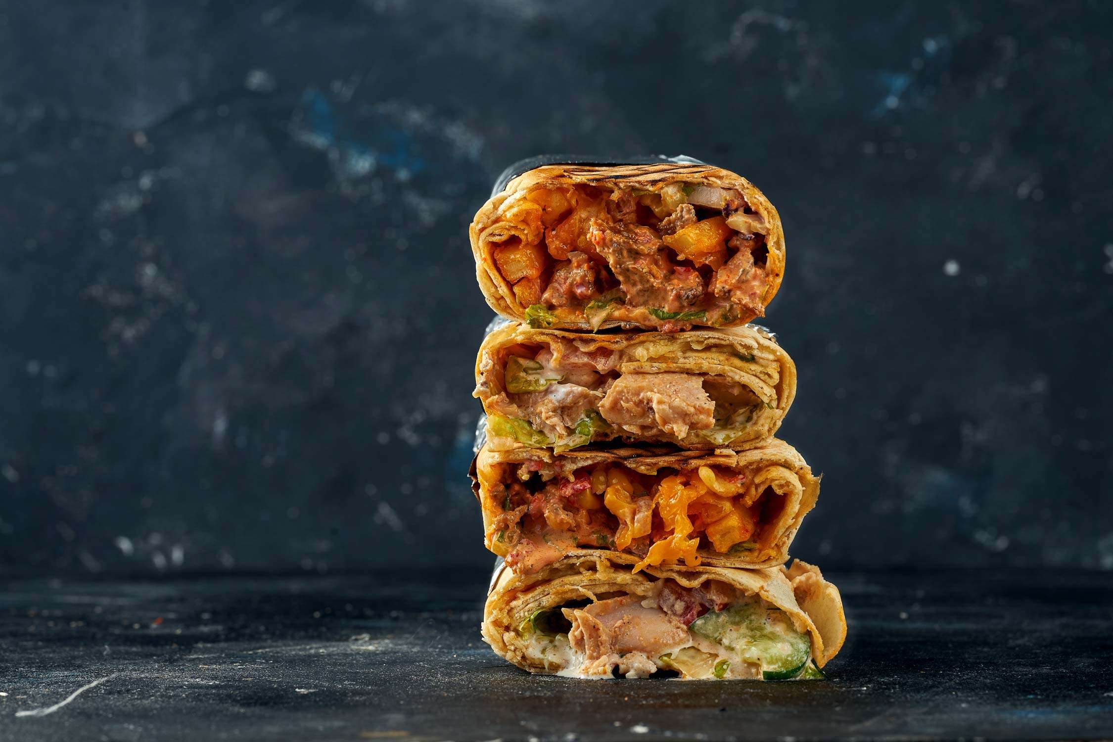 Shawarma stacked one on top of the other with meat and vegetable filling. 