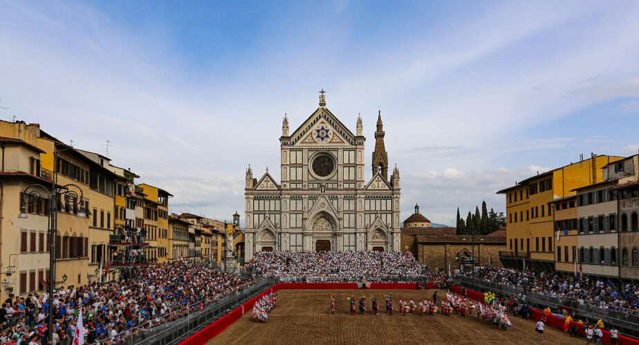 A large crowd gathers in front of the Basilica of Santa Croce in Florence