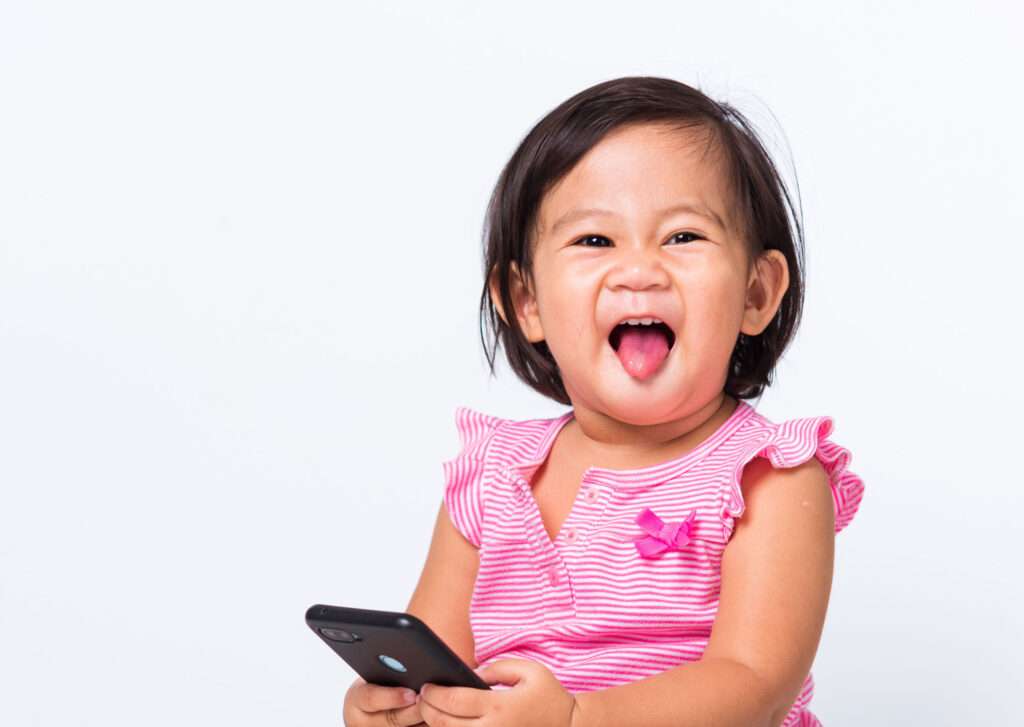 Cute baby child girl uses smartphone