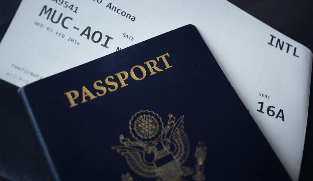 Close up of a passport in front of a bus ticket