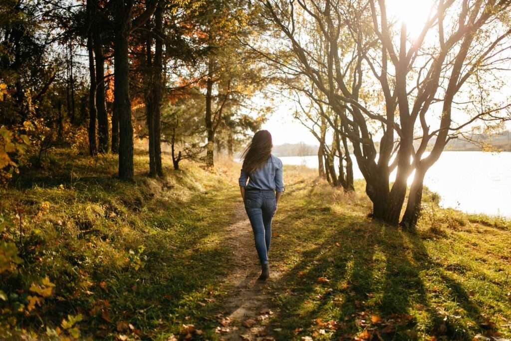 young woman walks in a forest park in autumn