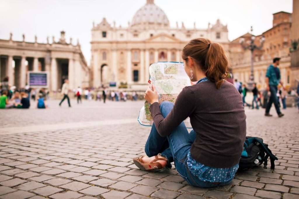 Joven turista estudiando un mapa en la plaza de San Pedro