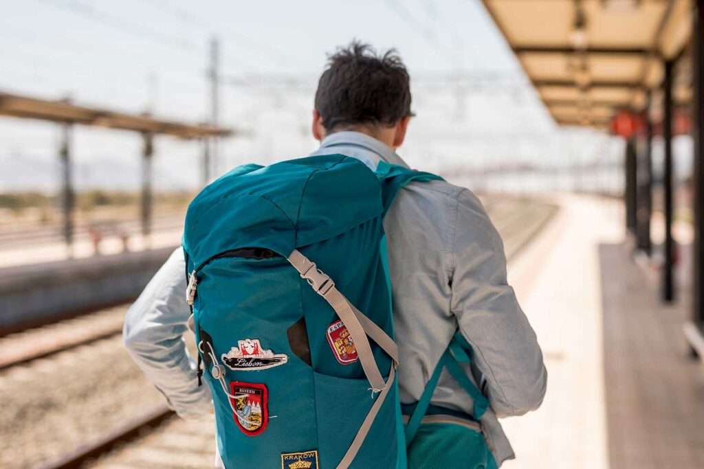 Traveler from behind with a large backpack on his shoulders