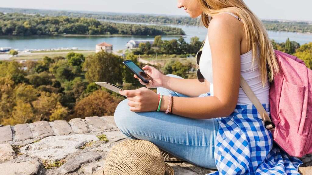 Woman using cellphone while hiking outdoors