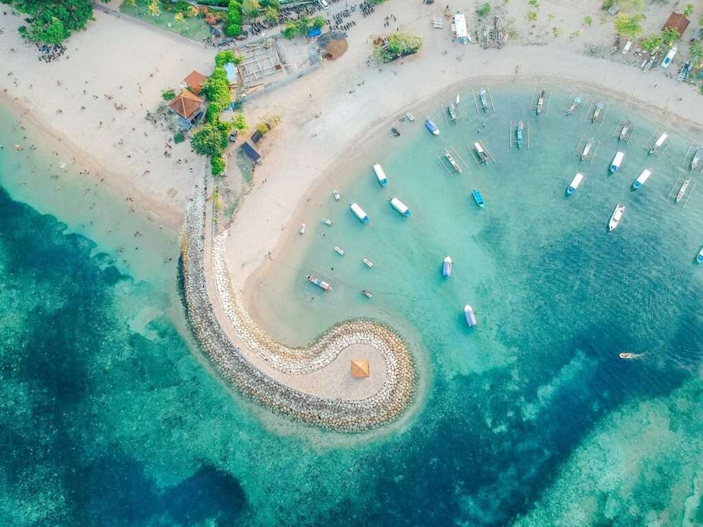 Aerial drone view of ocean, boats, beach, shore In Sanur Beach, Bali, Indonesia with with Traditional Balinese Fishing Boats amazing blue ocean. 