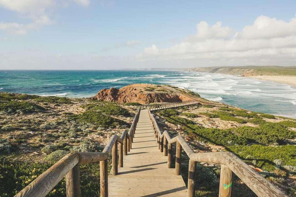 Wooden path leading to the Algarve coast, with the Atlantic Ocean in the background.